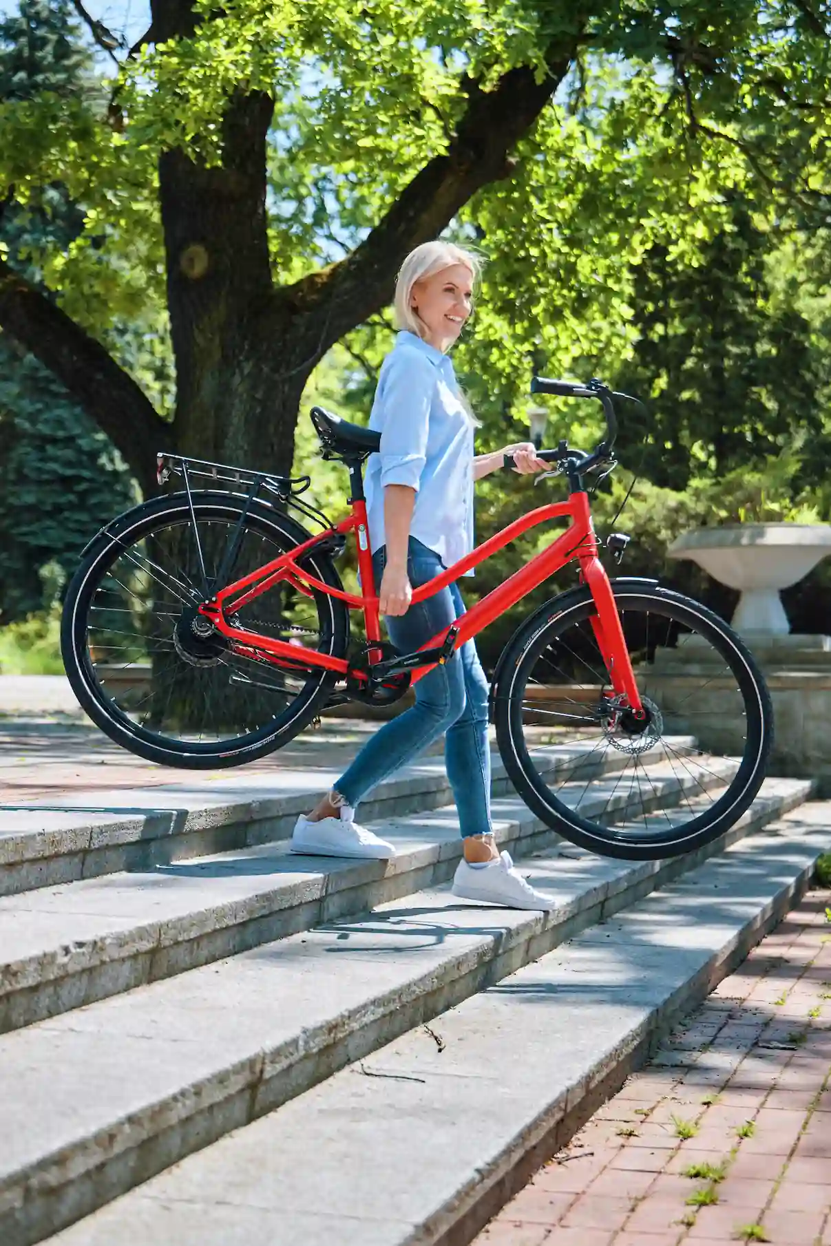 woman carrying light e-bike down the stairs